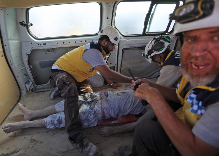 
Medlemmer af de såkaldte Hvide Hjelme redder sårede ud af ruinerne fra et af de senere dages angreb i Idlibprovinsen, udført af Assad-venlige styrker.    Foto: Omar Haj Kadour/Ritzau Scanpix