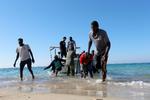 Migranter ses ved kysten i Libyen.  Foto: Ismail Zitouny/Ritzau Scanpix