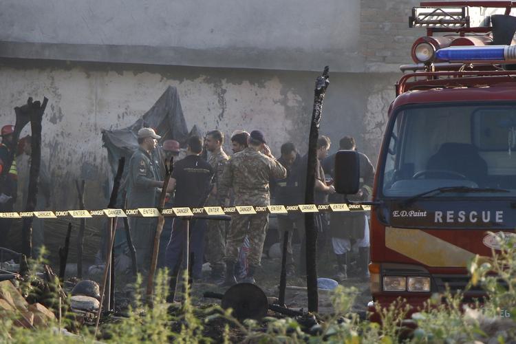 Redningsarbejdere i Pakistan i gang med arbejdet efter flystyrtet, der kostede 17 personer livet. Foto: Stringer/Ritzau Scanpix