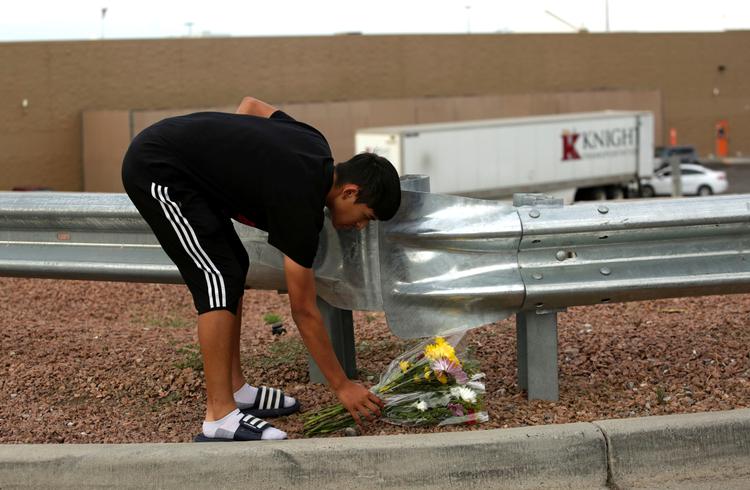 En sørgende borger lægger blomster nær det Walmart-supermarked  i El Paso, Texas, hvor et af weekendens  masseskyderier fandt sted.  REUTERS/Jose Luis Gonzalez
   Foto: Jose Luis Gonzalez/Ritzau Scanpix