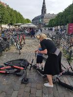 En kvinde forsøger at løfte et barn over væltede løbehjul på Højbro Plads. Foto: Rasmus Klinck, privatfoto