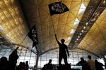 Som en tydelig advarsel til demonstrationerne har kinesiske statsmedier det seneste døgn bragt artikler om den massive oprustning af politistyrker langs grænsen til Hongkong. På billedet ses demonstranter med flag, der bærer teksten »Befri Hongkong. Vor tids revolution«. Foto: Tyrone Siu/Ritzau Scanpix