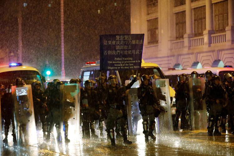 Det kom natten til mandag igen til voldsomme sammenstød mellem politi og demonstranter i Hongkong. På billedet hejser politiet et advarselsskiltover for demonstranterne. Foto: Willy Kurniawan/Ritzau Scanpix