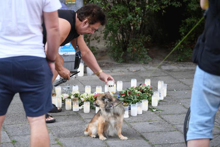 Naboer lægger blomster, der hvor en 30-årig kvinde mandag blev skudt og dræbt i Malmø. Politiet holder kortene tæt ind til kroppen om sagen.  Foto: 10090 Claudio Bresciani/tt/Ritzau Scanpix