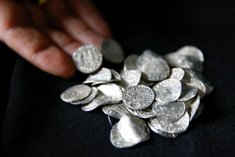 
En ansat på British Museum fremviser mønterne.     Foto: Henry Nicholls/Ritzau Scanpix