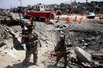 Afghanske sikkerhedsstyrker holder vagt, mens oprydningsholdet samler sig på det sted i Kabul, hvor en voldsom eksplosion dræbte 16 personer.  Foto: Str/Ritzau Scanpix
