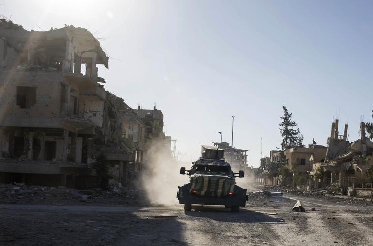 Et køretøj passerer gennem Raqqa i Syrien, kort tid efter Islamisk Stat var blevet drevet ud af byen. Nu bliver også den danske indsats mod Islamisk Stat styrket. Foto: Asmaa Waguih/Ritzau Scanpix