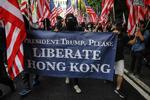 Demonstranter holder et banner med 'Befri Hongkong' sammen med det amerikanske flag, mens de går mod det amerikanske konsulat i Hongkong.    Foto: Vivek Prakash/Ritzau Scanpix