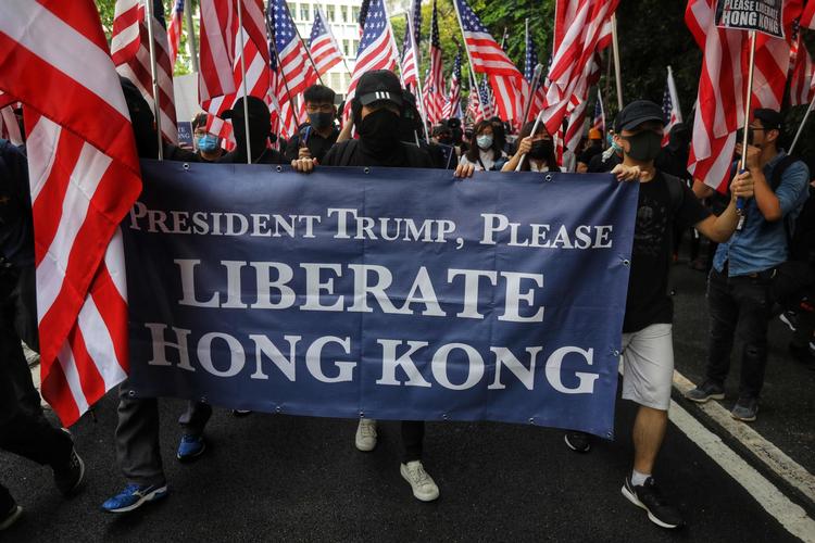 Demonstranter holder et banner med 'Befri Hongkong' sammen med det amerikanske flag, mens de går mod det amerikanske konsulat i Hongkong.    Foto: Vivek Prakash/Ritzau Scanpix
