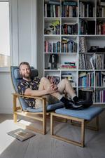  Rune Skyum-Nielsens slædestol og fodskammel fra Børge Mogensen er gået i arv i nogle generationer. Her holder han meget af at skrive og se fjernsyn. Men stolen har også lagt ryg til festligheder – blandt andet en kammerats fuldemandssyge og nogle, der forsøgte at være intime i den.  Foto: Mads Nissen/POLFOTO