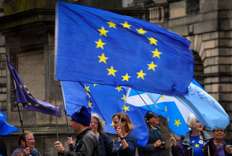 Aktivister holder EU's samt det skotske flag under en demonstration foran Edinburghs civile domstol i Edinburgh. Den har truffet afgørelse om, at premierminister Boris Johnsons beslutning om at suspendere det britiske parlament i fem uger og lige før udtræden af EU er ulovlig.
 Foto: Andy Buchanan/Ritzau Scanpix