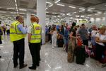 Britiske regeringsansatte er placeret ved en Thomas Cook indtjekningsskranke i Mallorca lufthavn. Storbritanniens regering har sat en kæmpeevakuering i gang, efter at rejseselskabet Thomas Cook er gået konkurs, og selskabets fly står på jorden. Foto: Enrique Calvo/Ritzau Scanpix
