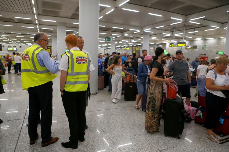 Britiske regeringsansatte er placeret ved en Thomas Cook indtjekningsskranke i Mallorca lufthavn. Storbritanniens regering har sat en kæmpeevakuering i gang, efter at rejseselskabet Thomas Cook er gået konkurs, og selskabets fly står på jorden. Foto: Enrique Calvo/Ritzau Scanpix