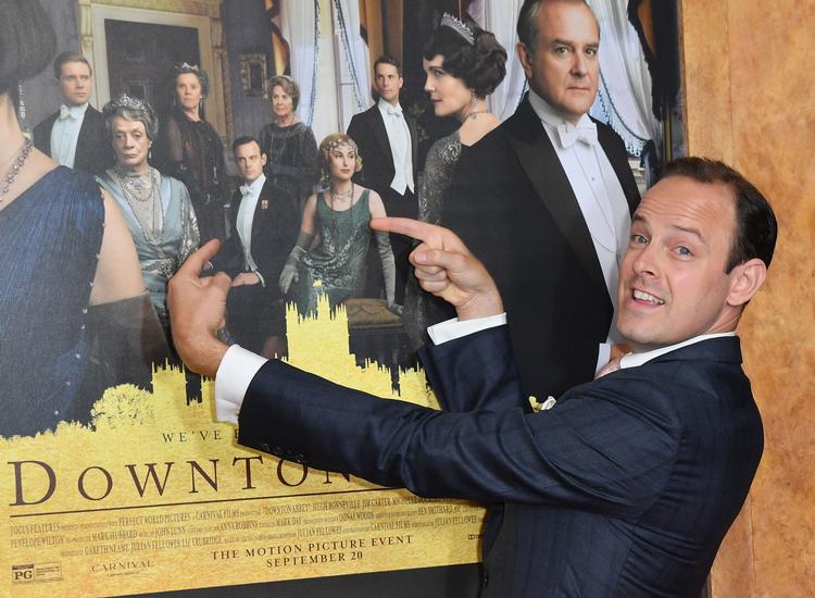 Den engelske skuespiller Harry Hadden-Paton ses her foran plakaten til 'Downton Abbey'-filmen, hvor han spiller rollen som Bertie Hexham. Foto: Angela Weiss/Ritzau Scanpix