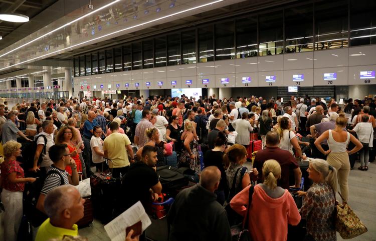 Britiske passagerer står i kø ved check-in-skrankerne i Dalaman lufthavnen i Tyrkiet. De skal fragtes hjem, efter at Thomas Cook natten til mandag gik konkurs. Foto: Umit Bektas/Ritzau Scanpix