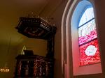 En begravelse er lettere at bære, hvis næste generation står klar til at tage over. Det hjælper også med et lyserødt skær fra Per Kirkebys vinduer i Gentofte Kirke. Foto: Per Munch