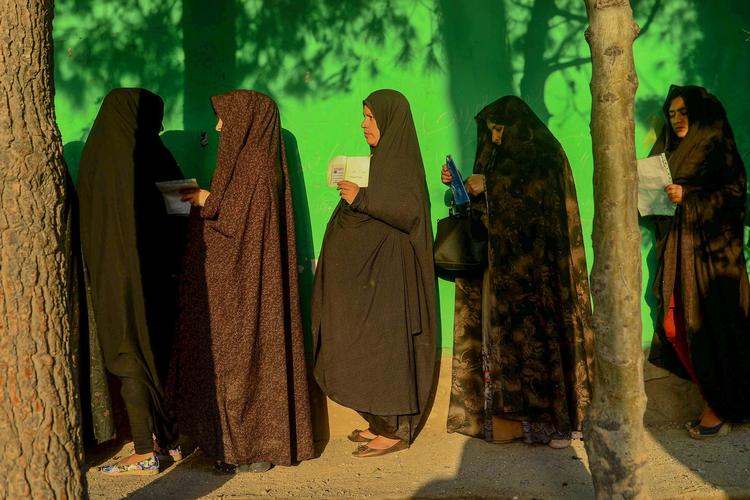 Kvinder står i kø til at stemme ved et valgsted i Herat, Afghanistan. Sikkerheden er stor ved valget, hvor urolighederne har været voldsomme. Foto: Hoshang Hashimi/Ritzau Scanpix