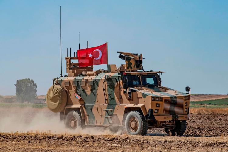 Tyrkisk militærkøretøj på patrulje i det nordlige Syrien ved byen Tel Abyad. USA og Tyrkiet har patruljeret området sammen - nu vil Tyrkiet gennemtvinge etableringen af en 'sikker zone', så det kan hjemsende flere millioner syriske flygtninge.
   Foto: Delil Souleiman/Ritzau Scanpix