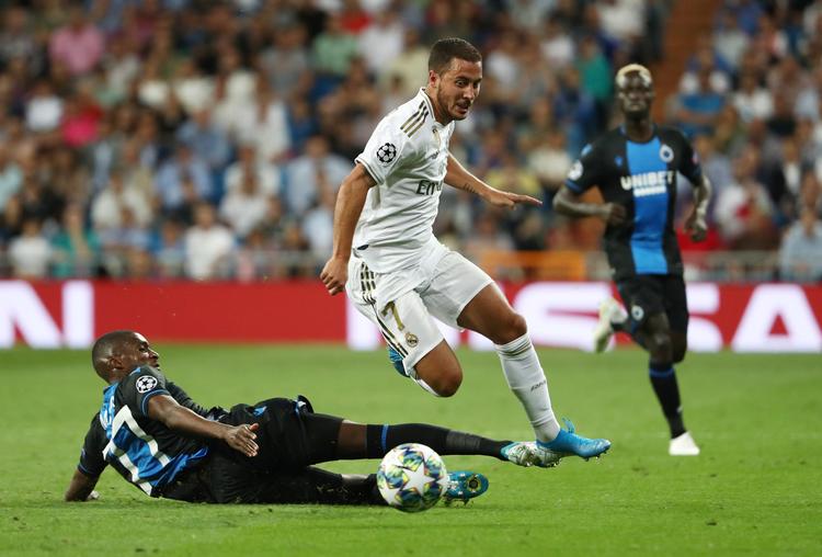 Eden Hazard forsøger her at slippe forbi Club Brugges Clinton Mata tirsdag aften i Madrid, men hverken belgieren eller Real-holdkammeraterne kunne levere varen i gruppe A-kampen, der sluttede 2-2.    Foto: Jon Nazca/Ritzau Scanpix
