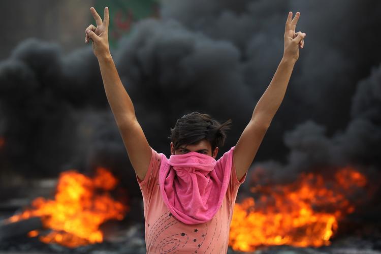 En irakisk demonstrant på gaden i Iraks hovedstad, Bagdad onsdag. Demonstranterne viste deres utilfredshed med regeringen, som de mener er skyld i stigende arbejdsløshed og faldende levestandard. Foto: Ahmad Al-rubaye/Ritzau Scanpix
