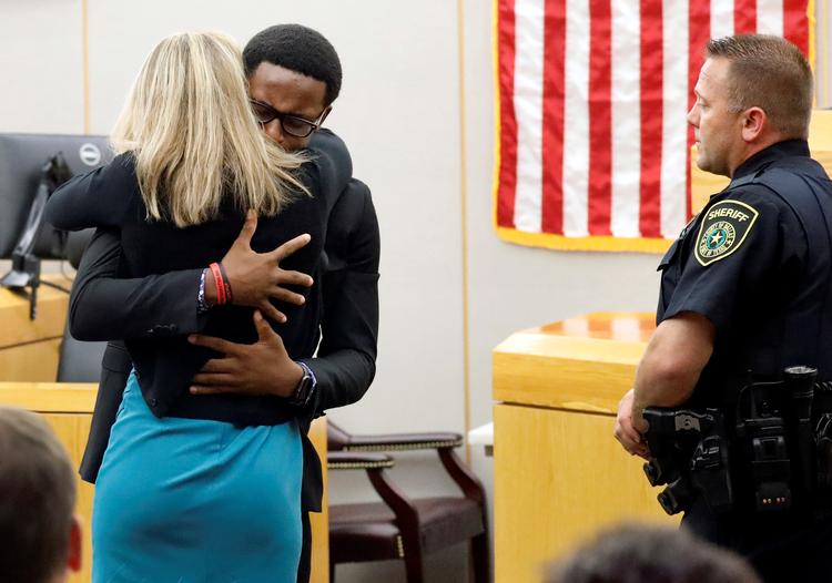 Botham Jeans yngre bror, Brandt Jean, giver et knus til tidligere betjent, Amber Guyger. Hun fik en dom på 10 år for drabet på Botham Jean.  Foto: Tom Fox/Ritzau Scanpix