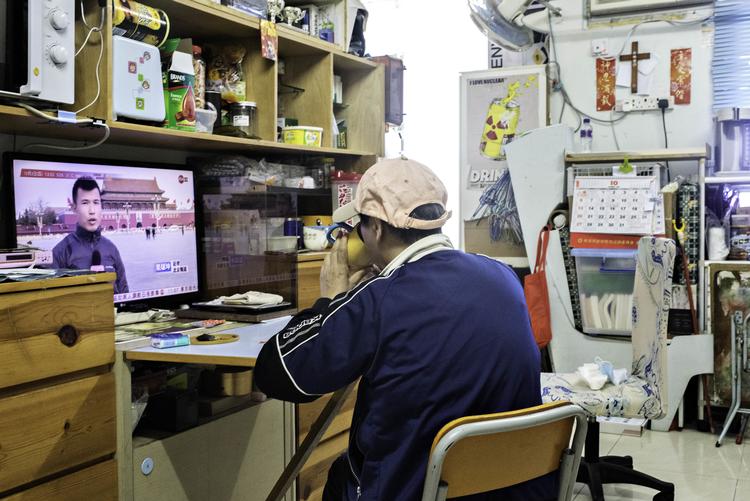 Yuk vil kun fotograferes bagfra, fordi hun frygter at blive genkendt. Hun følger med i nyhederne både fra Kina og Hongkong i familiens lille lejlighed. Foto: Claus Blok Thomsen