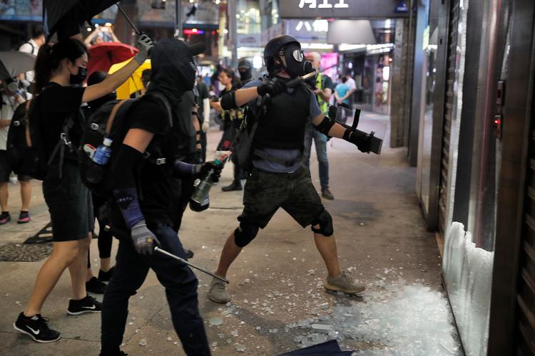 Demonstranter smadrer Bank of Chinas vinduer i Hongkong med totenschlægere. Foto: Jacob Ehrbahn/Politiken