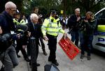 Politiet anholder her 83-råige Phil Kingston, som sprayede et klima-slogan på en mur i London.  Foto: Henry Nicholls/Ritzau Scanpix