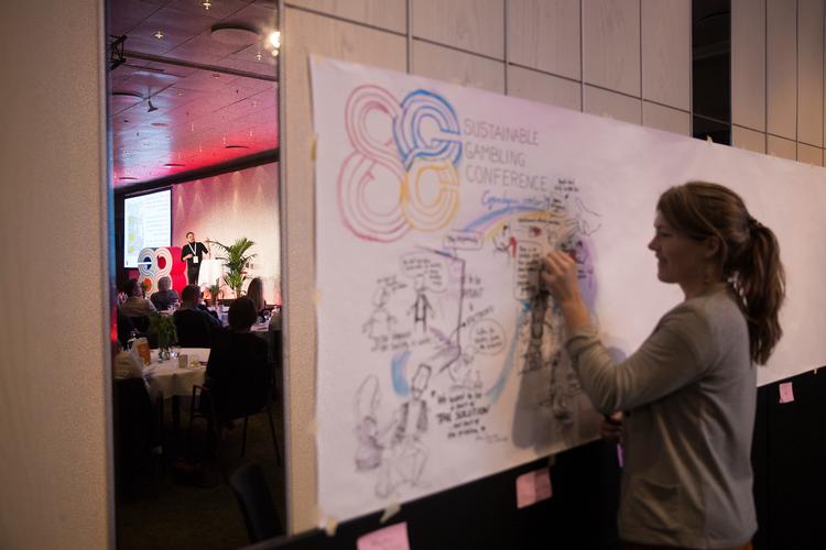 En billedkunster er blevet hyret til at nedfælde de vigtigste pointer fra konferencen om onlinespil på Radisson Blu Scandinavia. 
   Foto: Thomas Borberg/POLFOTO