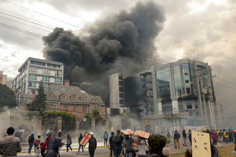 Demonstranter trængte lørdag aften dansk tid ind i en regeringsbygning i Quito og satte ild til den. Foto: Rodrigo Buendia/Ritzau Scanpix