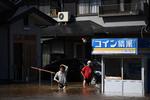 Borgere vader gennem gaden i Shibata-distriktet, efter Hagibis ramte Japan lørdag. Foto: Charly Triballeau/Ritzau Scanpix