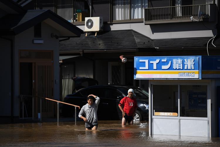 Borgere vader gennem gaden i Shibata-distriktet, efter Hagibis ramte Japan lørdag. Foto: Charly Triballeau/Ritzau Scanpix