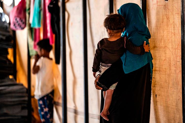 
    Blandt de internerede i lejrene i de kurdiske områder sidder mange børn uden familie. og dem er Red Barnet særligt bekymret for, hvis kampene mellem tyrkiske og kurdiske styrker breder sig. Her er det en saudiarabisk frivillig, der i september passede 24 forældreløse børn i Ain Issa-lejren.
   Foto: Delil Souleiman/Ritzau Scanpix