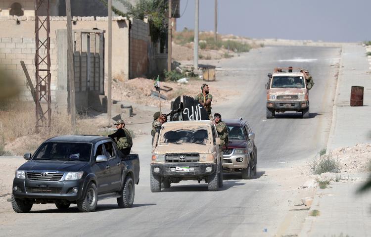 Tyrkisk støttede oprørsstyrker ses her på grænsen til Syrien ved byen Tel Abyad.  Foto: Khalil Ashawi/Ritzau Scanpix