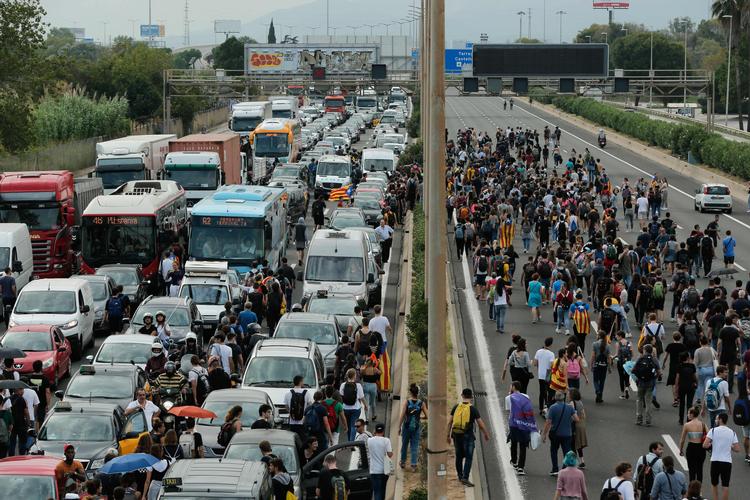 Demonstranter på vej mod lufthavnen El Prat mandag blokerer trafikken. Protesterne fortsætter i Barcelona og  i byens lufthavn tirsdag. 