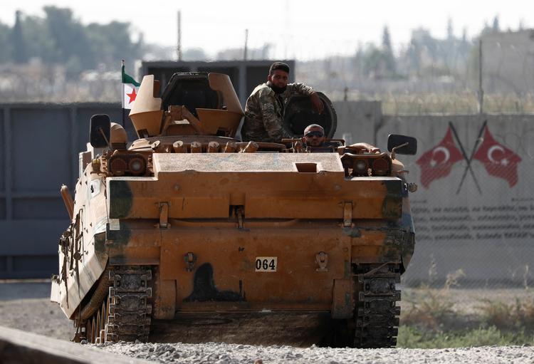 Tyrkisk-finansierede syriske tropper sidder på en pansret mandskabsvogn. 14.000 lejesoldater af denne slags benyttes af Tyrkiet i kampen mod de kurdiske militser.
   Foto: Murad Sezer/Ritzau Scanpix