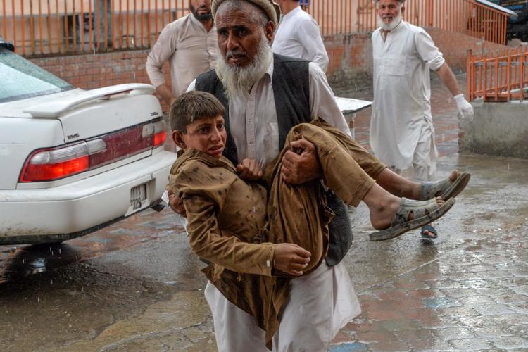 En frivillig bærer en såret dreng til hospitalet. 
  Foto: Noorullah Shirzada/Ritzau Scanpix