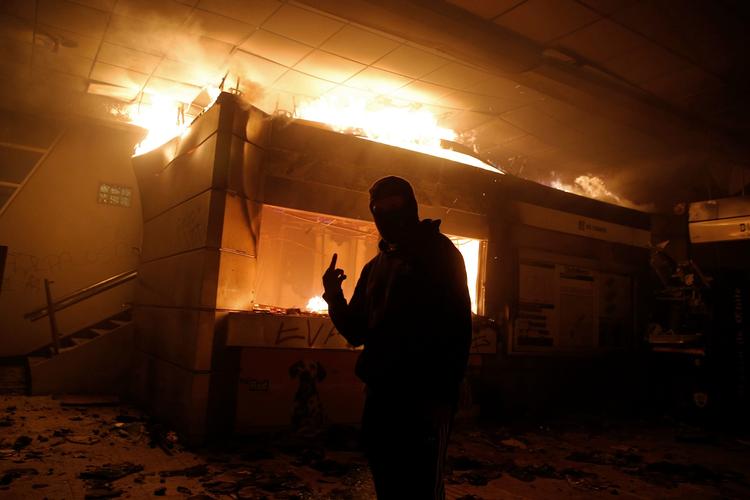 Flere metrostationer i Chiles hovedstad, Santiago, står i brand, efter at protester mod højere billetpriser fredag udviklede sig voldeligt. Foto: Javier Torres/Ritzau Scanpix