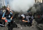 Demonstranter flygter fra tåregas under protester i Chiles hovedstad Santiago.  Foto: Ivan Alvarado/Ritzau Scanpix