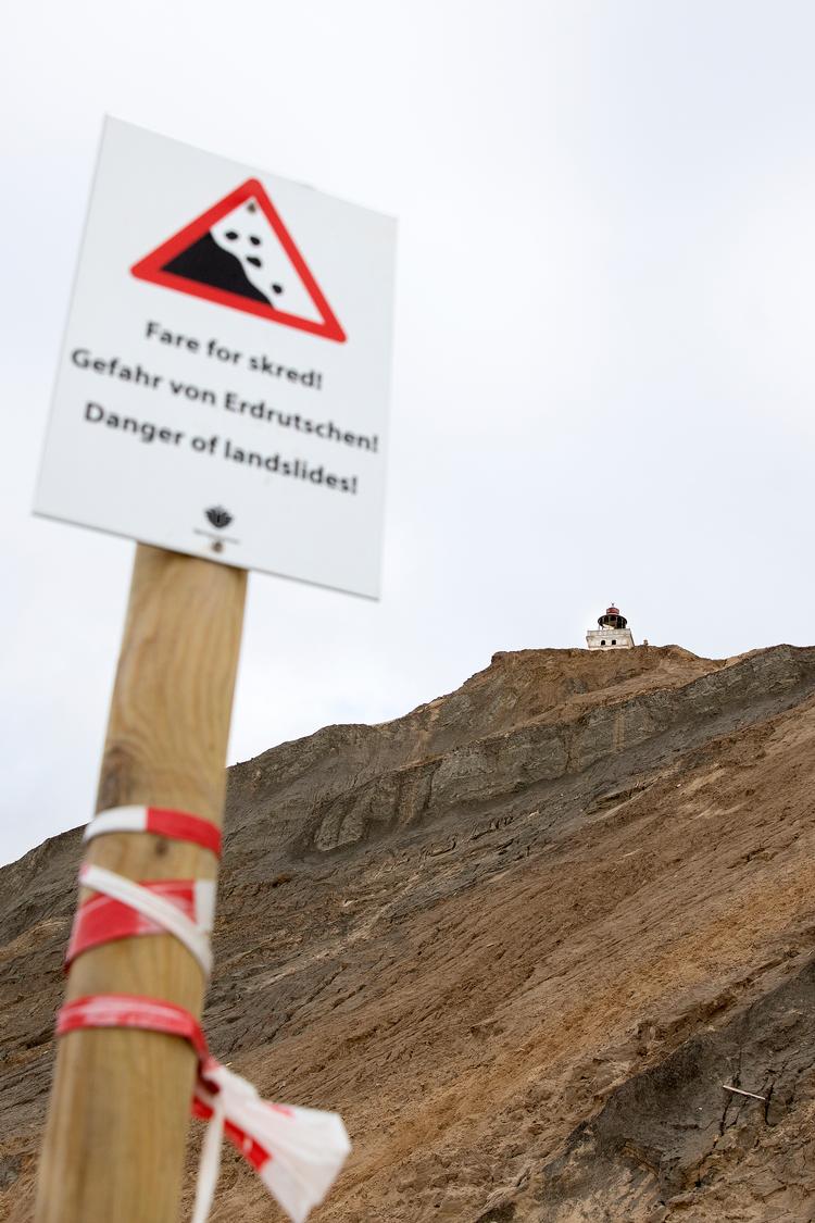En lille trykprøve i går af hydraulikken, der skal løfte Rubjerg Knude Fyr i dag, gik efter planen. Fra stranden kan man se de mørke striber af ler og det lyse sand, der står lodret i klinten og er årsagen til, at sandet flyver rundt ved knuden.   Foto: Finn Frandsen/POLFOTO