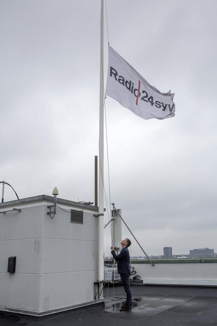 Radio24syv får at vide at radioen lukker.  Mikael Bertelsen hejser flaget på halvt. Foto: Peter Hove Olesen.  Foto: Peter Hove Olesen/POLFOTO