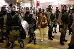 En kvinde baner sig vej gennem nogle betjente i forbindelse med en demonstration i Hongkong i mandags.  Foto: Kim Kyung-hoon/Ritzau Scanpix