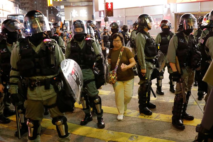 En kvinde baner sig vej gennem nogle betjente i forbindelse med en demonstration i Hongkong i mandags.  Foto: Kim Kyung-hoon/Ritzau Scanpix