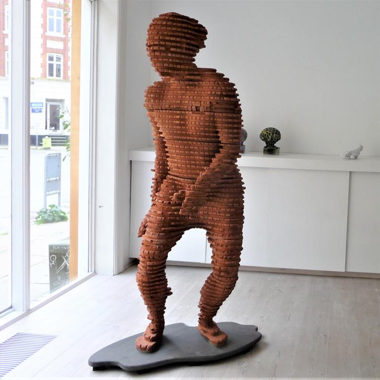 Allerede når man står ude på gaden og kigger ind i Ann Linnemanns galleri, er det den store mand i rødler, der fanger blikket. Han er ung og vild - og han er i fuld fart på vej ud i verden.  Foto: Ann Linnemann