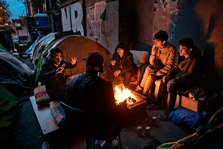 Mange migranter lander i Paris, Frankrig, hvor tusindvis lever i tynde campingtelte under broer, på gader og oven på varmeriste. 
De fem unge mænd omkring bålet er fra Afghanistan og Sudan. De har alle sammen været flere år i Europa, og de har alle sammen fået afslag på asyl i henholdsvis Sverige, Tyskland og England. Nu håber de på at få asyl i Frankrig.  Foto: Jacob Ehrbahn/POLFOTO