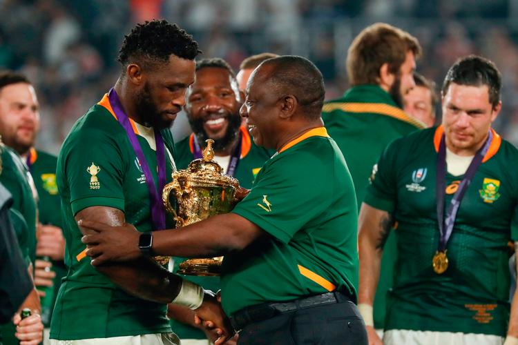 
  Sydafrikas præsident Cyril Ramaphosa (th.) lykønsker anføreren Siya Kolisi  (tv.) med VM-pokalen. 
   Foto: Odd Andersen/Ritzau Scanpix
