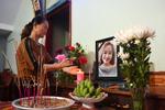 En pårørende tænder et lys ved et billede af vietnamesiske Bui Thi Nhung, som frygtes at være blandt de døde i lastbilcontaineren.  Foto: Nhac Nguyen/Ritzau Scanpix