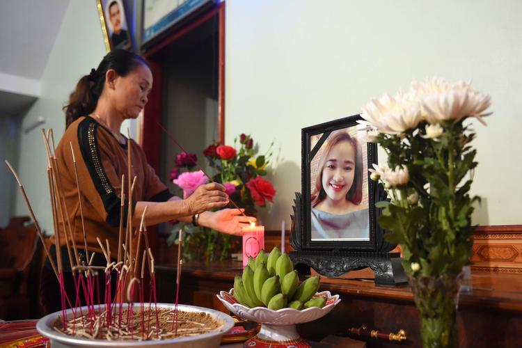 En pårørende tænder et lys ved et billede af vietnamesiske Bui Thi Nhung, som frygtes at være blandt de døde i lastbilcontaineren.  Foto: Nhac Nguyen/Ritzau Scanpix