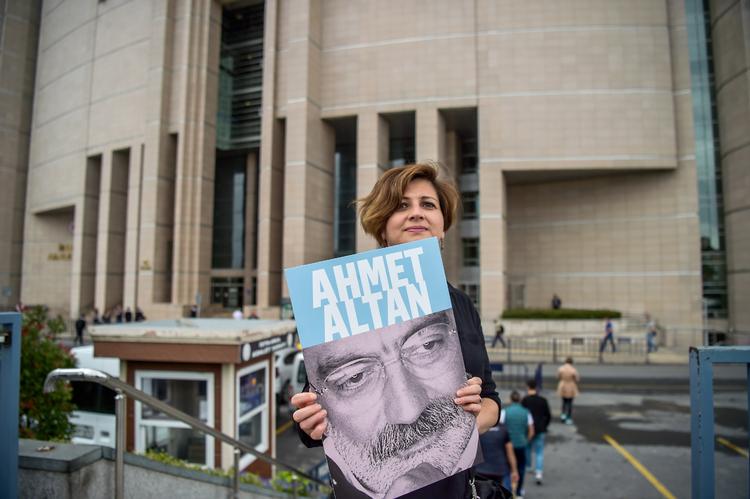 En journalist bærer på billedet af forfatter, Ahmet Altan, foran retsbygningen i  Istanbul, hvor Altan fik en fom på livsvarigt fængsel.  Foto: Ozan Kose/Ritzau Scanpix