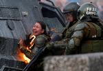 Nedskæringspolitik og en stor ulighed i Chile har udløst særdeles voldsomme sammenstød mellem politi og demonstranter i hovedstaden. Her er en betjent ramt af en brandbombe. Foto: Jorge Silva/Ritzau Scanpix